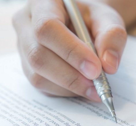 Hand with pen over application form